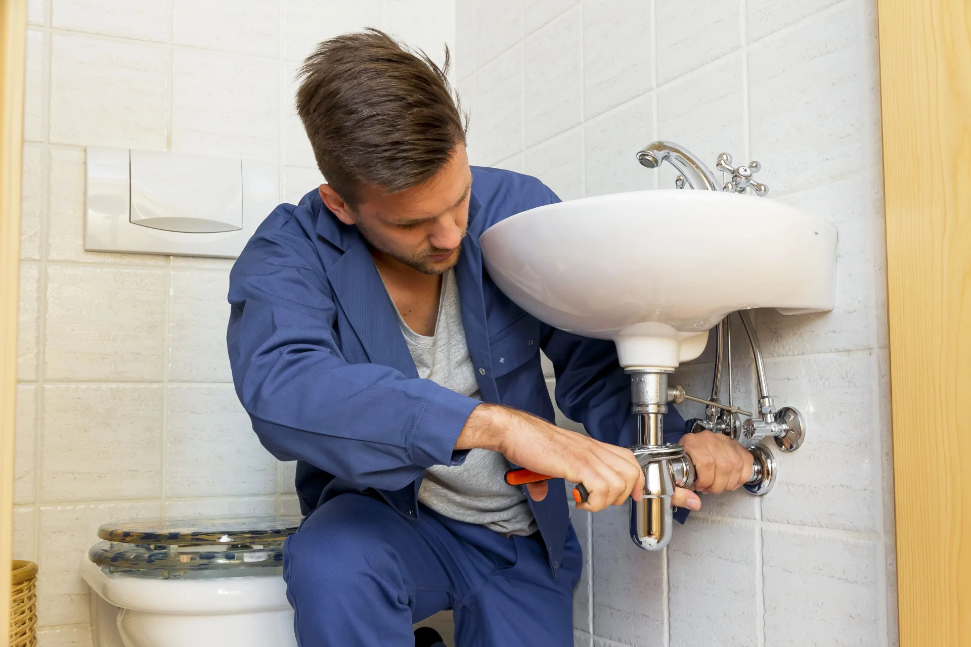 Plumber inspecting kitchen sink drains